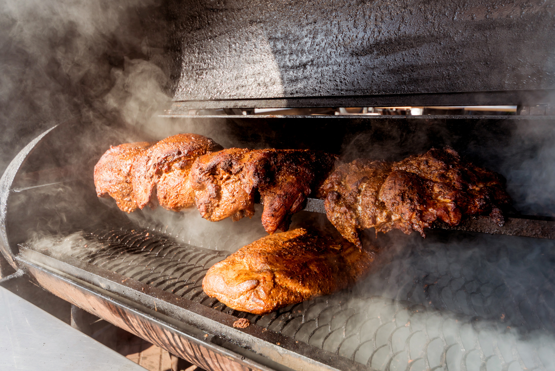 Large barbecue smoker grill at the park. Meat prepared in barbecue smoker.